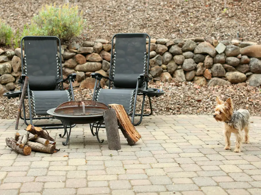 Two chairs beside a fire pit on a stone patio