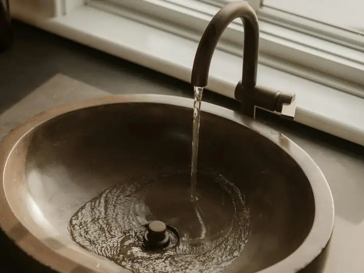 Water flowing into a bronze sink basin