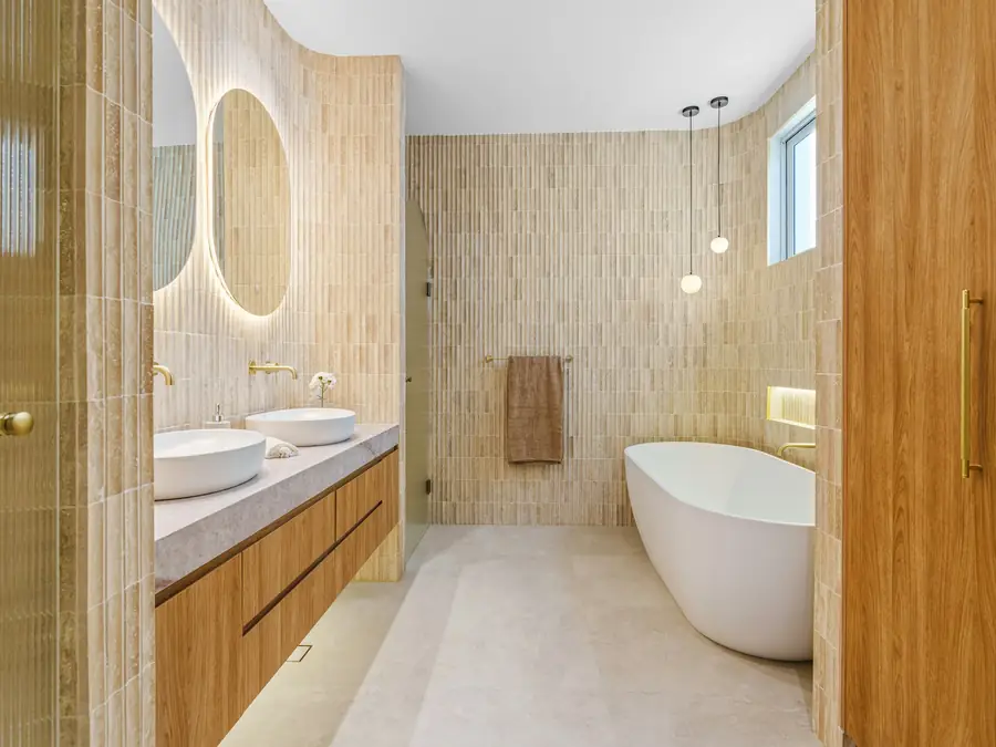 Bathroom with double sinks and a freestanding tub